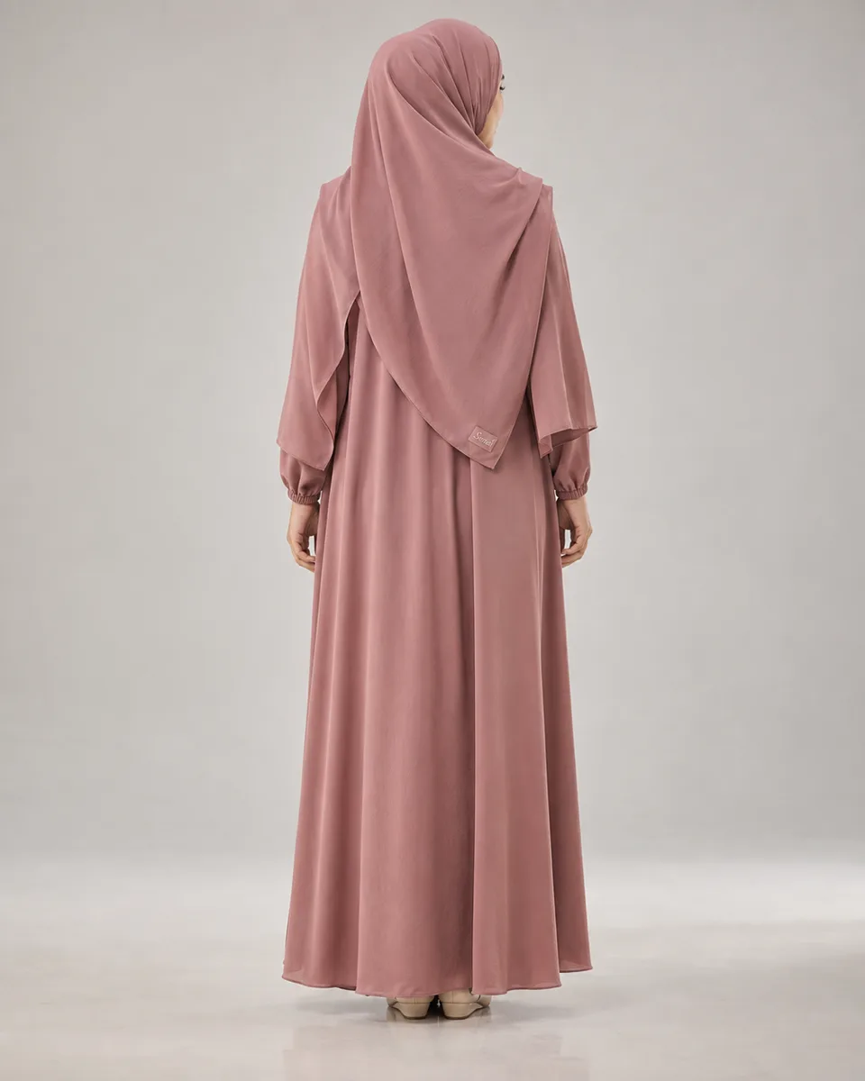 {{model_look}} difoto tepat dari belakang dalam {{product}} {{brand_name}}, memperlihatkan drape hijab dan jatuhnya kain